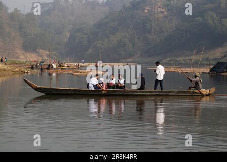 Students ride on a boat as they cross the Sangu River in the winter in Bandarban, Bangladesh on February 6, 2023. Stock Photo