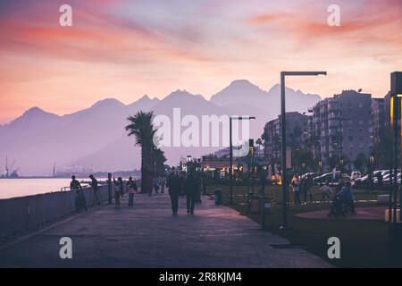 17 December 2022, Antalya, Turkey: pedestrian path on the Antalya embankment. People are walking and enjoying the majestic sunset Stock Photo