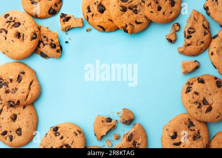 Frame made of many delicious chocolate chip cookies on light blue background, flat lay. Space for text Stock Photo