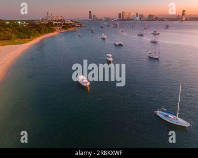 Aerial view of boast and yachts at anchor on a calm bay during twilight at Southport on the Gold Coast at Queensland in Australia Stock Photo