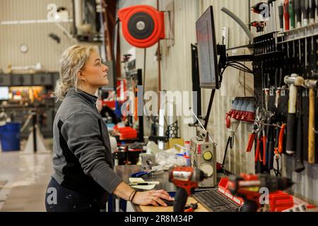 Young female industrial worker working in factory Stock Photo
