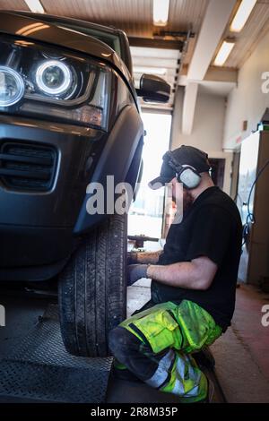 Mechanic in garage changing tires on car Stock Photo