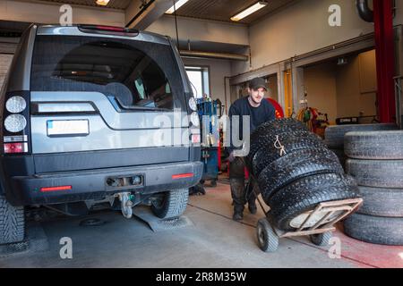 View of mechanic working on changing tires in garage Stock Photo