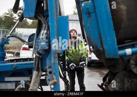 Young female construction worker operating machinery Stock Photo