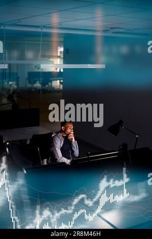 Male finance specialist working in office at night Stock Photo
