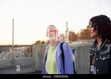 Smiling young women walking together and talking Stock Photo