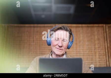 Senior man with headphones using tablet Stock Photo
