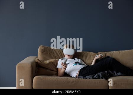Boy wearing virtual reality goggles during VR experience Stock Photo