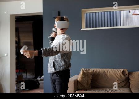 Boy wearing virtual reality goggles during VR experience Stock Photo