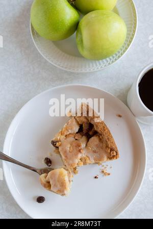 Slice of apple pie and a cup of coffe on white table. Top view Stock Photo