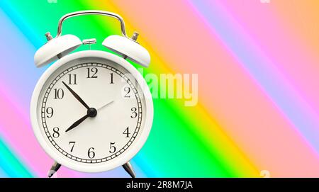 white retro alarm clock on a colorful backdrop Stock Photo