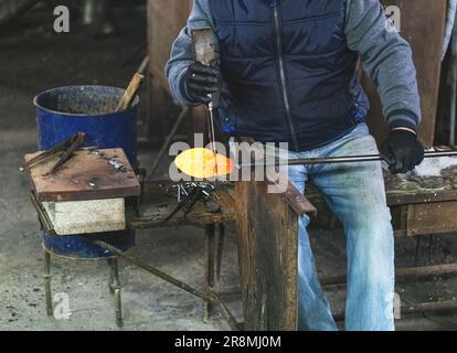 Shaping glass bowl with wet tool. Rounding the hot glass Stock Photo