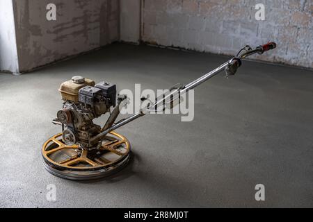 Concrete floor finishing on construction site. Concrete screed with power trowel machine Stock Photo
