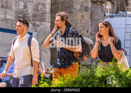 Three young people with backpacks walking through city center - Tours, Indre-et-Loire (37), France. Stock Photo