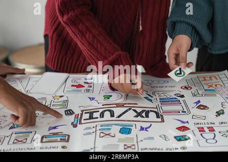 Creative designer choosing color samples for mobile responsive website development with UI UX. Developing wireframe sketch layout design mockup on Stock Photo