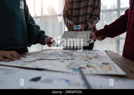 Creative designer choosing color samples for mobile responsive website development with UI UX. Developing wireframe sketch layout design mockup on Stock Photo