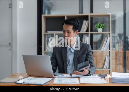 Business man working on project for analyzing company financial report balance statement with documents at modern office. business,economy, market Stock Photo