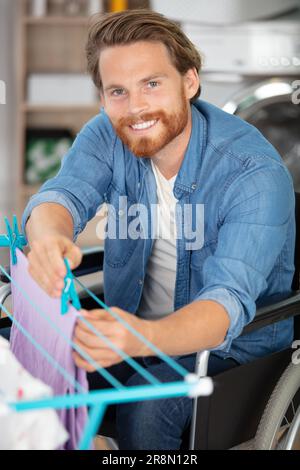 disabled man on wheelchair doing laundry Stock Photo