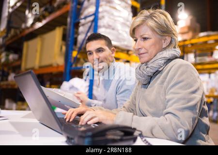 portrait of managers are looking a laptop in a warehouse Stock Photo