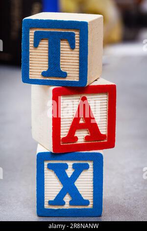 Tax written in stacked kids alphabet playing blocks with selective focus Stock Photo