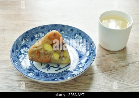 sticky rice steam with pork and salt egg of Chinese Duanwu festival on plate couple hot tea cup Stock Photo