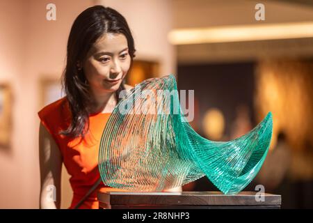 London, UK.  22 June 2023. A staff member with 'Ku-82 (free Essence-82', 2015, by Niyoko Ikuta on the A Lighthouse called Kanata, Tokyo, stand at the preview of the first Treasure House Fair at the Royal Hospital Chelsea.  The art and antiques fair brings together more than 50 of the best British and international dealers across numerous disciplines and centuries and takes its place in the summer calendar after Masterpiece art fair closed in 2022.  The fair is open to the public 22 to 26 June.  Credit: Stephen Chung / Alamy Live News Stock Photo