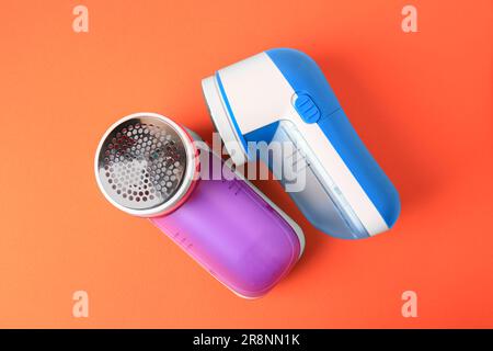 Different fabric shavers on orange background, top view Stock Photo