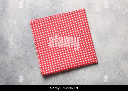 Red checkered tablecloth on light gray textured table, top view Stock Photo