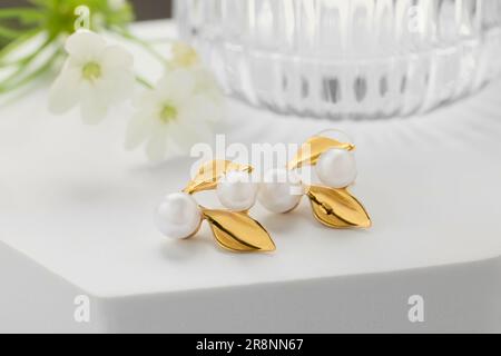 Beautiful earrings on white podium. Luxury jewelry Stock Photo