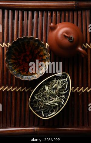 Aromatic Baihao Yinzhen tea and teapot on wooden tray, flat lay. Traditional ceremony Stock Photo