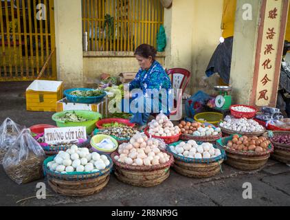 A middle-aged female market vendor sells eggs in the central market in Kontum, in the Central Highlands of Vietnam. Stock Photo