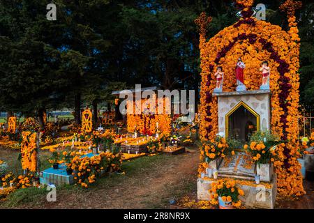 Graves decorated with marigold flowers are seen at a cemetery during the Day of the Dead festivities in Cucuchucho, Michoacán, Mexico. Stock Photo
