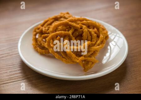 Murukku is a savory, crunchy snack originating from the Indian subcontinent.Its an Indian traditional tea time snack chakli, a deep fried snack, It is Stock Photo