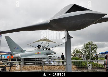 Eurofighter EF2000 Typhoon fighter jet demonstrator at Farnborough International Airshow arms fair, with a wingman UAV combat drone on pole. Raining Stock Photo