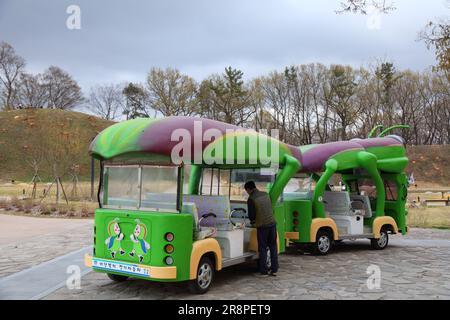 GYEONGJU, SOUTH KOREA - MARCH 26, 2023: Tourists ride the silkworm electric tour bus in historic sites of Gyeongju, South Korea. Silkworm was an impor Stock Photo