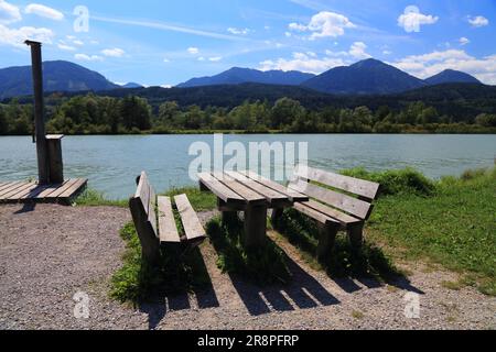 Picnic table by the river Drava near Spittal an der Drau town in Austria. Summer in the Alps. Stock Photo