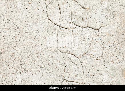 Old wall covered with cement plaster with deep cracks. Stock Photo