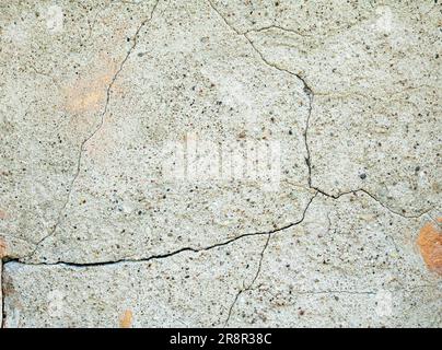 Old wall covered with cement plaster with deep cracks. Stock Photo