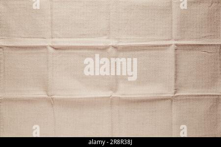 Abstract background of cream colored waffle towel with folds. Stock Photo