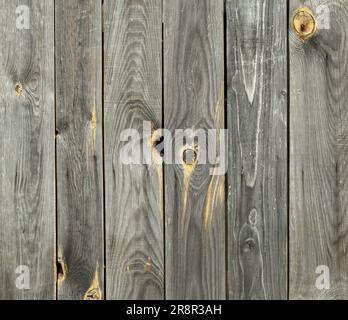 Contrasting wooden background from old weathered vertical pine boards with cracks and knots Stock Photo