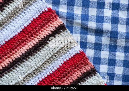 striped colored grandmother's carpet multicolored red white black and fabric in a cage sinai with white as a background Stock Photo