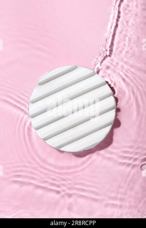 Plaster podium in water on pink background Stock Photo