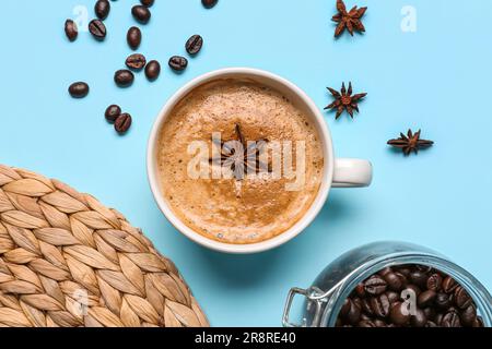 Cup of hot espresso and coffee beans on blue background Stock Photo