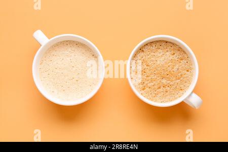 Cups of hot espresso on orange background Stock Photo