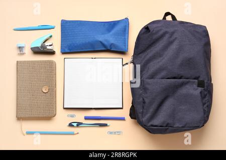 Notebooks with backpack, pencil case and different stationery on pale orange background Stock Photo