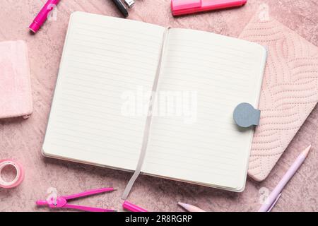Notebooks with different stationery on grunge pink background Stock Photo