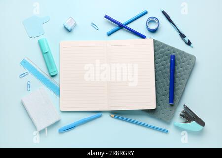 Notebooks with different stationery on blue background Stock Photo