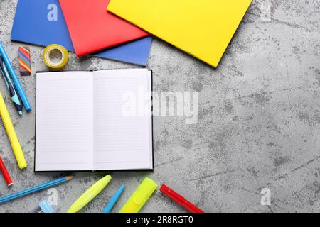 Notebooks with different stationery on grunge grey background Stock Photo