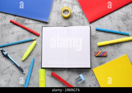 Notebooks with different stationery on grunge grey background Stock Photo