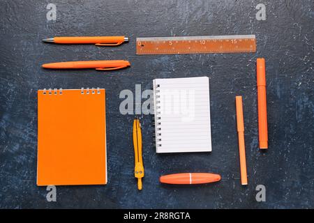 Notebooks with different stationery on grunge dark blue background Stock Photo